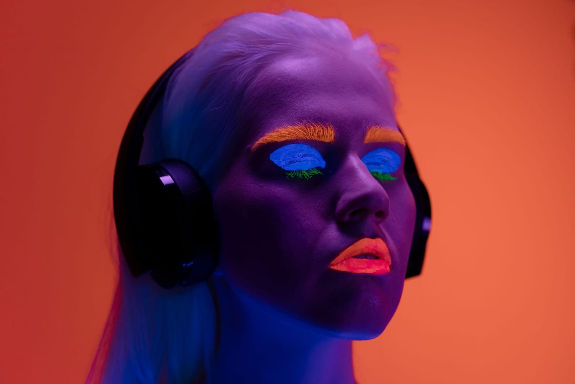 A portrait with neon make-up and headphones
