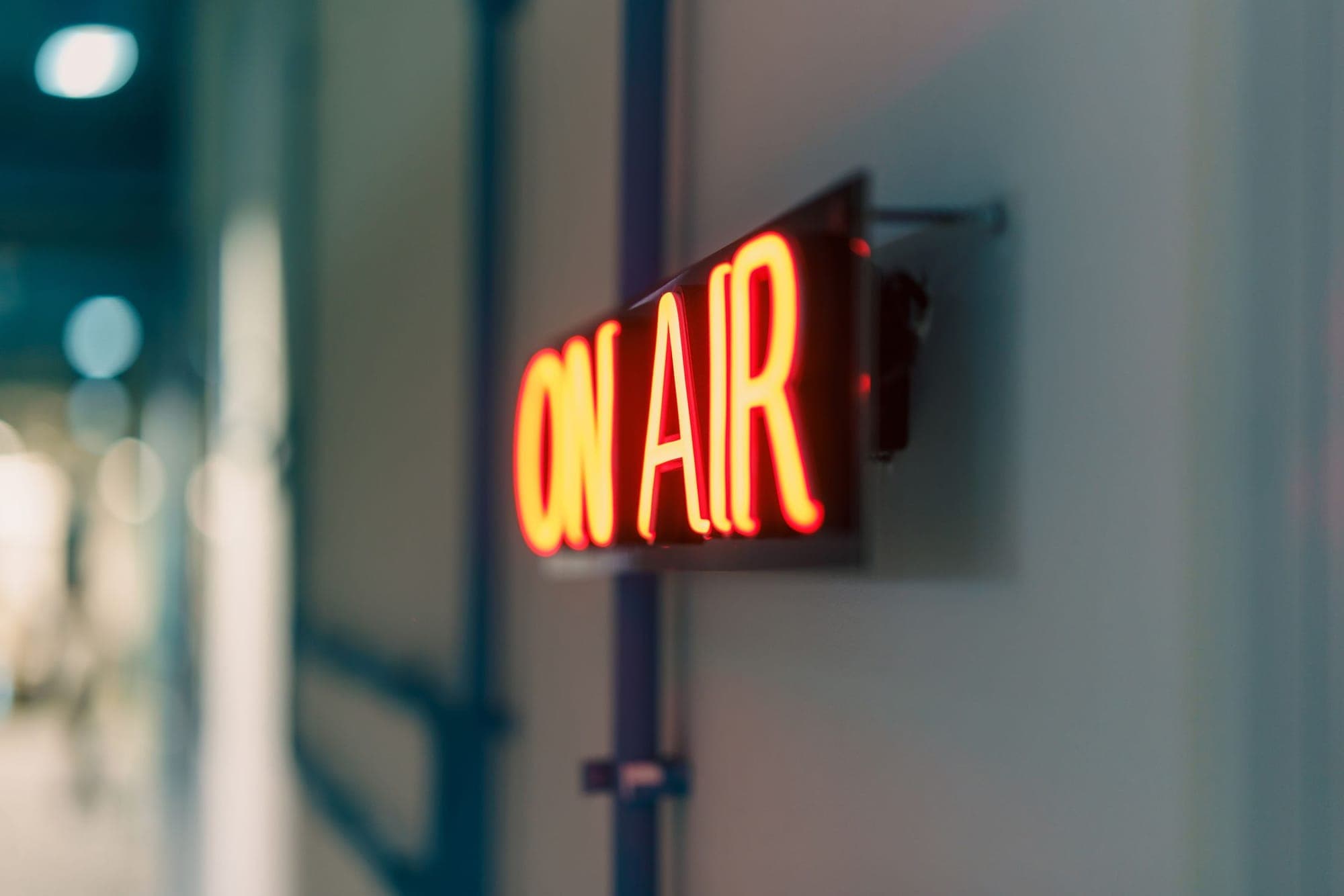 A red ON AIR sign mounted on a studio wall